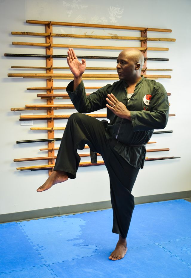 Sifu Moses holding a one-legged Tai Chi stance in the training hall